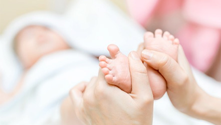 Мама делает массаж при дисплазии ног у ребенка