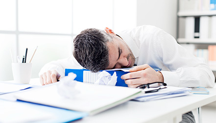 Мужчина с низким гемоглобином спит на работе