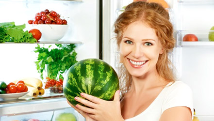 Девушка хранит арбуз в холодильнике